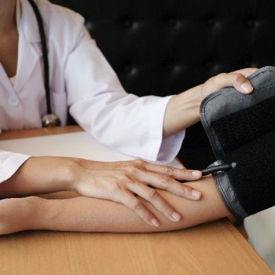 Doctor checking  patient arterial blood pressure. Health care.